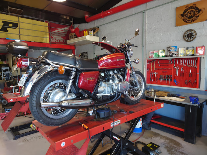 Photo d'une moto en réparation dans le garage.